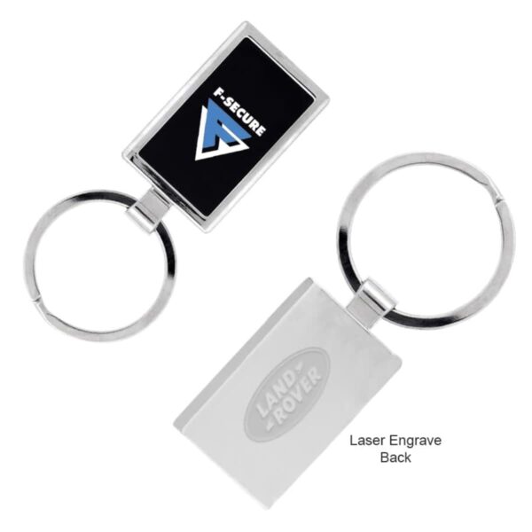 Two metal keychains with rectangular plaques. One plaque has a black background with F-SECURE and a blue triangle logo. The other is engraved with LAND ROVER on a silver background. Both keychains have circular rings attached.