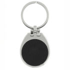 A silver keychain with a circular, black textured center and a round keyring. The design is sleek and modern.
