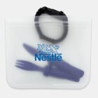 A transparent pouch with the Nestlé logo contains a navy blue spork and a black paracord bracelet with a clasp.