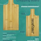 An advertisement for the Ozi Bamboo Chopping Board featuring a wooden board with a handle. The board has JARLSBERG engraved on it. Text highlights features like eco-friendly material, antibacterial properties, and multifunctionality.