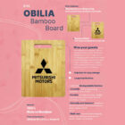 A bamboo cutting board features the Mitsubishi Motors logo. Descriptive text on a pink background highlights its features: made from 100% natural bamboo, FDA approved, versatile, naturally antibacterial, and multi-use. Dimensions are 280mm x 215mm x 14mm.