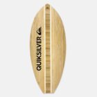 A wooden skimboard with a natural bamboo pattern, featuring the QUIKSILVER logo in black letters on one side. The board has a pointed tip and tail, with a central vertical wood accent.