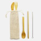 A set of wooden utensils including a knife, fork, spoon, and chopstick, accompanied by a straw cleaning brush. They are placed next to a beige cloth bag, intended for storage or transport.