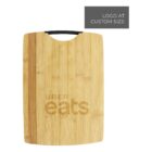 A wooden cutting board with a black handle and Uber Eats logo engraved on the surface. A gray rectangle in the top right corner features the text LOGO AT CUSTOM SIZE.
