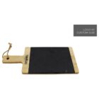 A wooden cutting board with a black slate center and a handle featuring a hanging loop. The board has a label and an inset area for a custom logo, shown in gray.
