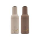 Two cylindrical bottles, one beige and one brown, with silver tops. Each is labeled CHANDON with a stylized gold arc above the text. The bottles are standing upright on a plain white background.