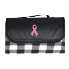 A folded picnic blanket with a black and white checkered pattern. It has a black flap with a pink ribbon symbol on it. A black handle is attached to the top for easy carrying.