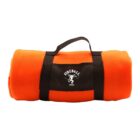 An orange fleece blanket rolled up with a black strap for carrying. The strap features a logo and text that reads Fireball Whisky with a dragon emblem.