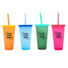 Four colorful reusable cups with lids and straws are lined up. The cups are orange, light blue, green, and pink, each with a straw matching its lid. Each cup displays the text YOUR LOGO HERE in black.