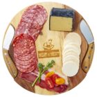 A round wooden board featuring sliced salami, a wedge of dark-rinded cheese, round crackers, and strips of cured meat. Garnished with cherry tomatoes and broccoli. Two decorative knives rest on the sides of the board.