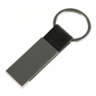 A metal keychain with a rectangular metallic tag attached to a circular keyring. The tag is connected to the ring by a short black leather strap.