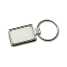 Silver rectangular keychain with a blank, white central panel and a round metal ring for holding keys. The design is simple and minimalistic.