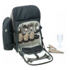 A black picnic backpack with an open front displaying utensils, plaid napkins, glasses, plates, and a storage pouch. A glass and two folded plaid napkins are placed beside the backpack.