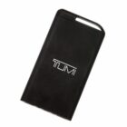 A black portable power bank with the TUMI logo displayed on its front. The device has a rectangular shape with slightly rounded edges and a small handle at the top.