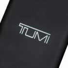 Close-up of a black case with TUMI printed in white bold letters on it.