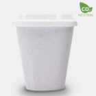 Eco-friendly, white biodegradable cup with a lid against a plain background. The cup has a speckled texture, and theres a CO2 Neutral label with a green leaf on the upper right corner.