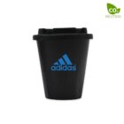 A reusable black cup featuring the Adidas logo in blue on the front. The cup has a black lid and a CO2 Neutral label in the top right corner, indicating its eco-friendly production.