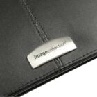 Close-up of a black leather surface with neat stitching and a metal nameplate near the edge. The plate is inscribed with image collection in lowercase letters.