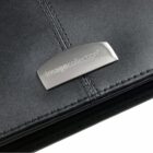 A close-up of a sleek, black leather folder or binder with a metallic plate on the corner displaying the words imagecollection®. The leather has a stitched detail running vertically beside the plate.