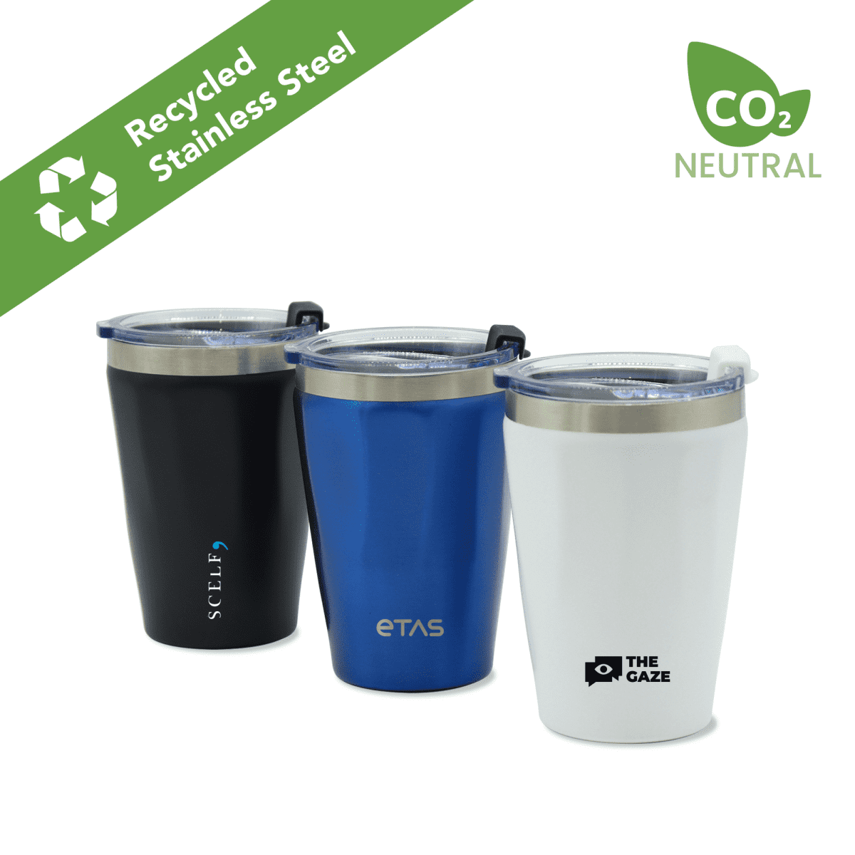 Three stainless steel travel mugs with plastic lids. From left to right: black, blue, and white with logos. A green triangle in the top left reads Recycled Stainless Steel with a recycle icon. A CO2 Neutral icon is on the top right.