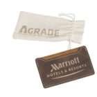 A brown leather luggage tag with Marriott Hotels & Resorts embossed on it. It is attached to a drawstring pouch with the Agrade logo and tagline Because everyone deserves an upgrade.