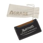 A black Marriott Hotels & Resorts luggage tag with white stitching and lettering. It is attached to a drawstring pouch labeled A-GRADE.