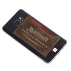 A smartphone with a brown leather cardholder attached to the back, displaying the logo Marriott Hotels & Resorts. A credit card is partially visible inside the cardholder.