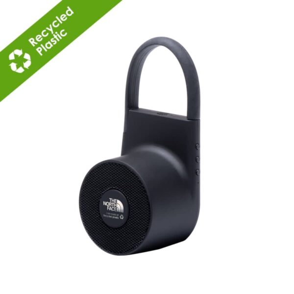 Black portable Bluetooth speaker with a handle from The North Face, featuring Recycled Plastic text in a green corner banner. The speaker has control buttons on the side and a circular front grille.