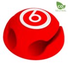 A red, dome-shaped cable holder with four rounded slots, featuring a white circle with a red b logo on top. A CO2 Neutral label is displayed in the top right corner.