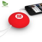 A red Uniqlo-branded charging device with a retractable cable is connected to a smartphone playing music. The top left corner displays a CO2 Neutral logo.