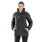 A person wearing a black quilted winter jacket with blue zipper accents and hands in pockets. The jacket has a hood, and the person is smiling, standing against a plain white background.