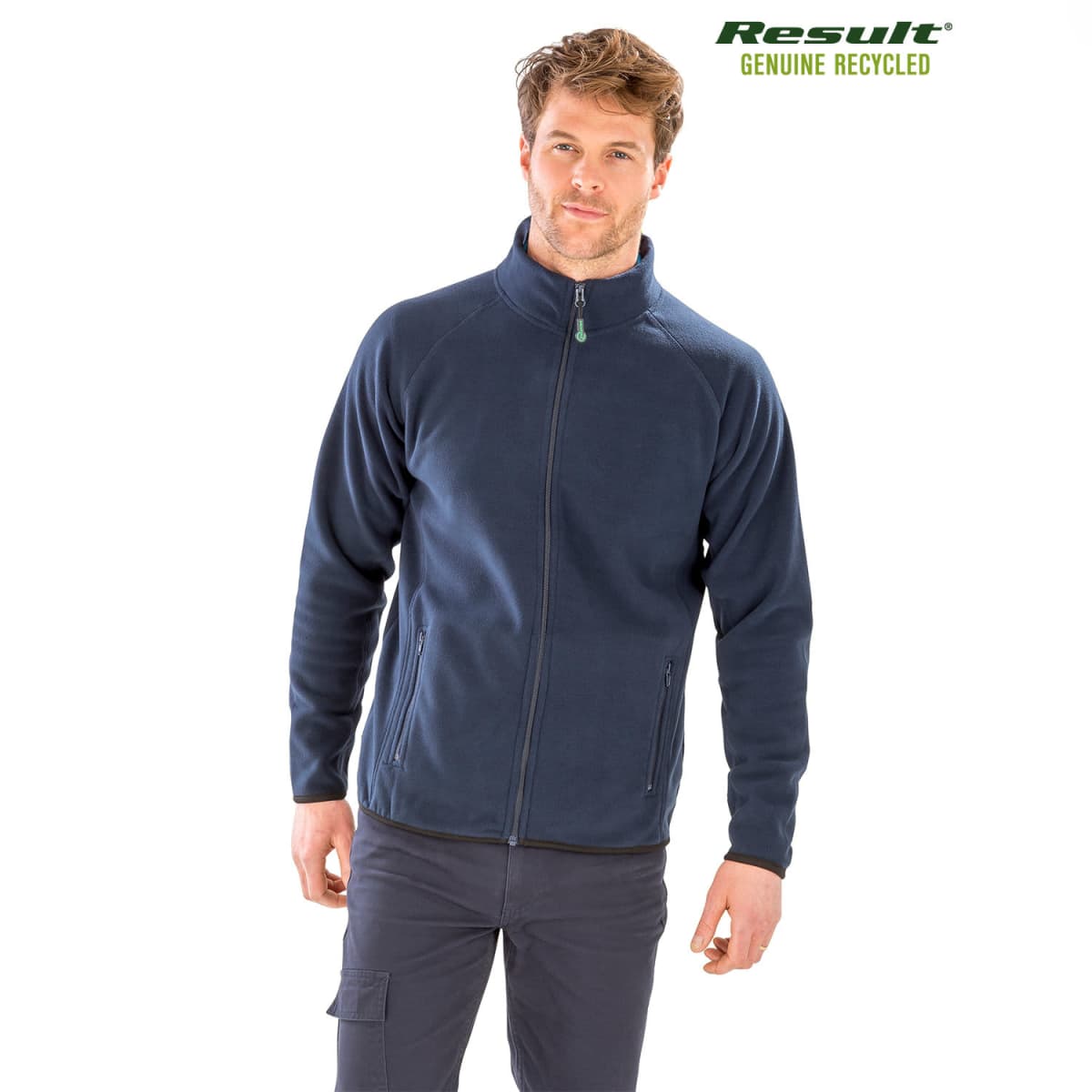 A man is wearing a navy blue zip-up fleece jacket and dark pants, standing against a white background. The jacket has pockets and a high collar. Result Genuine Recycled is printed in green text at the top-right corner.