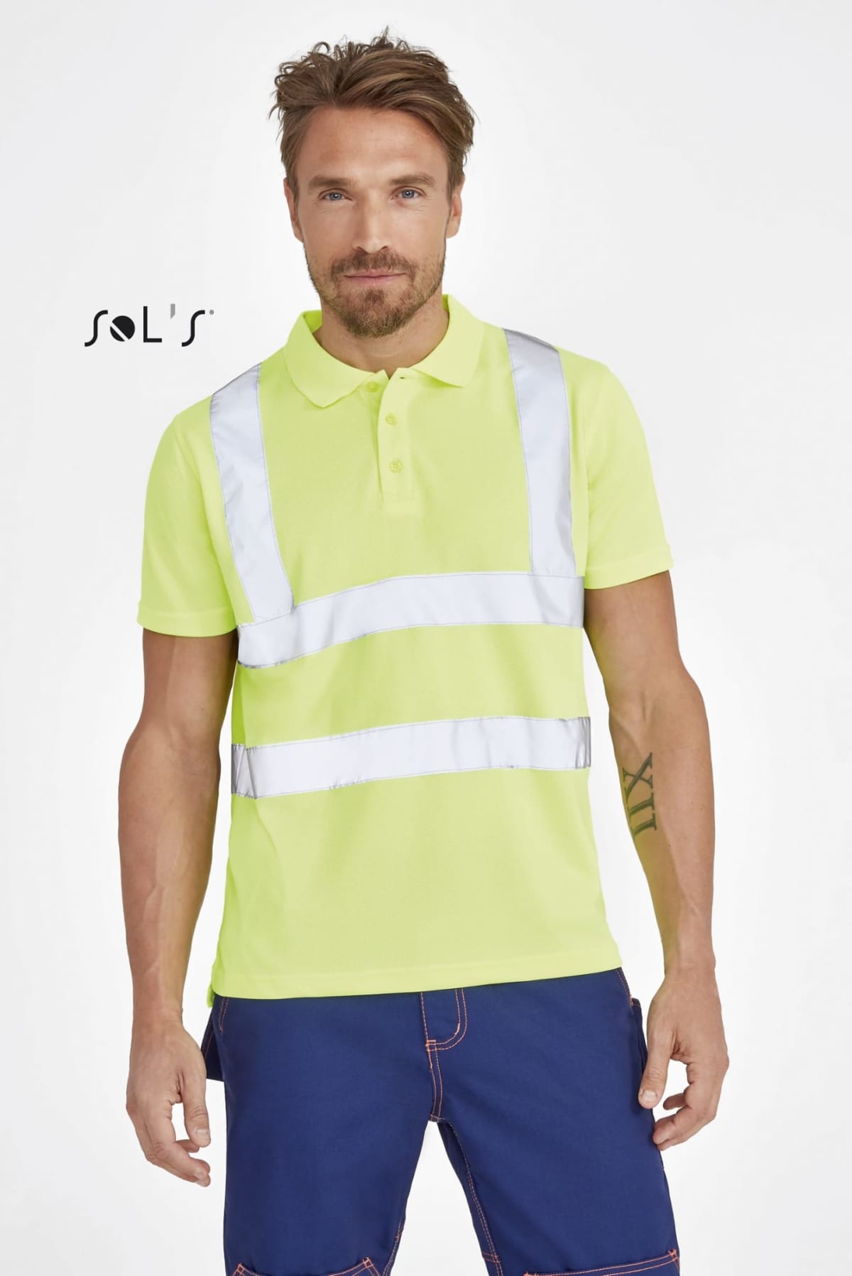 Man wearing a bright yellow safety shirt with reflective stripes and blue pants. He stands facing forward with one hand relaxed by his side. The background is plain white with a logo on the left side.