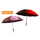 Two open umbrellas with red and black panels. One umbrella features a geometric design with the word Aegis and a pink element. An orange label above says Digital Print. Both have red shafts and black handles.