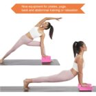 Two women perform yoga poses on mats using pink blocks. The first stands in a side stretch, the second is in a cobra pose. A banner above reads, Nice equipment for pilates, yoga, back and abdominal training or relaxation.