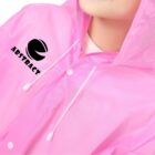 Person wearing a pink raincoat with ABSTRACT and a logo on it.