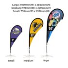 Three teardrop banners are displayed in different sizes: small (750mm x 1900mm), medium (970mm x 3000mm), and large (1090mm x 3880mm). Each banner has unique designs, including a vibrant illustration and logos.