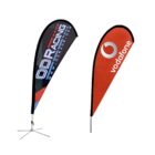 Two teardrop-shaped advertising banners with different designs. The left banner is black with ODRacing in white and red text. The right banner is red with a white logo and vodafone in lowercase white letters. Both have metal stands.