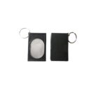 Two black rectangular keychains are shown. The keychain on the left features a transparent oval section, while the one on the right has a solid black surface. Both keychains have a metallic ring attached.