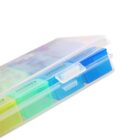 Close-up of a transparent plastic weekly pill organizer with visible blue and green compartments. The lid is slightly open, revealing the word NIGHT on the compartments.