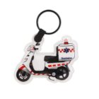 Keychain in the shape of a white and red emergency scooter with a black keyring. The word Bombeiros and a blue star of life symbol are on the cargo box, indicating a connection to firefighting or medical services.