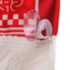 A close-up of a red and white textile with a checkered pattern and fringes. A transparent suction cup is attached to the fabric with a white elastic loop. The fabric is hanging vertically.