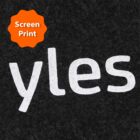 Close-up of the word yles in white, screened onto dark fabric. An orange starburst label at the top-left corner reads Screen Print.