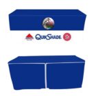 Two blue table covers with a white center stripe, featuring the QuikShade logo flanked by a pelican graphic and two red circular logos. The covers have white trim along the bottom edges.