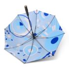 An open umbrella with a black handle features a modern geometric pattern in shades of blue, white, and gray. The design includes circles and abstract shapes, giving it a contemporary look.