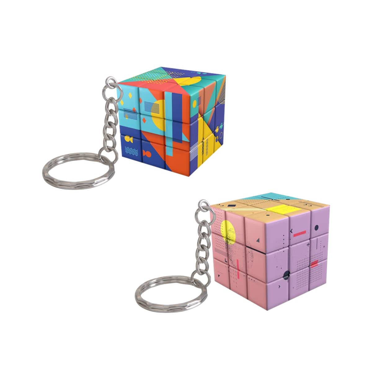 Two colorful keychain cubes with geometric and abstract patterns. The top cube features vibrant blues, reds, and yellows, while the bottom cube showcases pastel pinks and purples. Both have metal key rings attached.