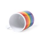 White mug on its side with a rainbow stripe design around the body, featuring red, orange, yellow, green, blue, and purple stripes. The mug has a plain white interior and a handle on the left side against a white background.