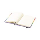 An open notebook with a rainbow-colored cover, displaying blank pages. A black ribbon bookmark is visible, laid over the center. The notebook is shown on a plain white background.