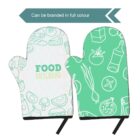 Two green and white oven mitts with illustrated patterns of food items like tomatoes, carrots, and cheese. Text above indicates they can be branded in full color.
