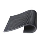 A black, textured anti-slip mat partially rolled on a white background. The mat appears flexible, with a grid-like surface pattern designed for grip.